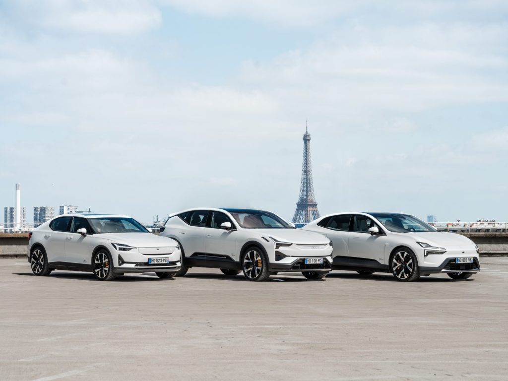 Tre hvite biler som står ved siden av hverandre på en parkeringsplass