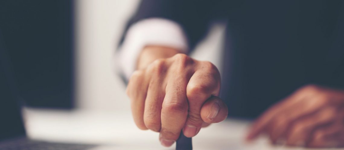 Close-up Of A Person's Hand Stamping With Approved Stamp On Document At Desk